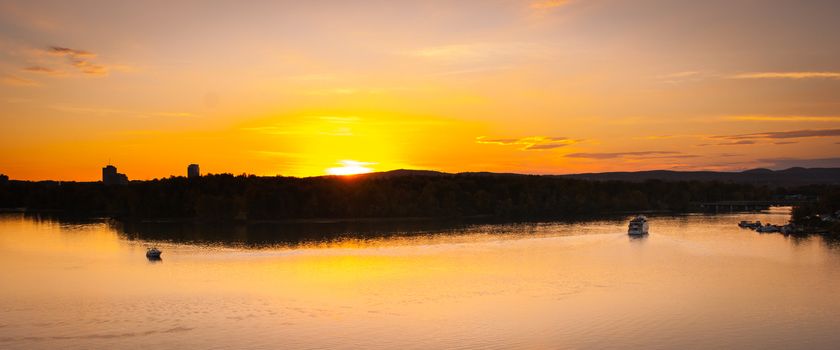 A riverboat of sight-seers cruise the river on a lovely warm summer evening