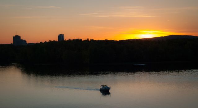 A riverboat of sight-seers cruise the river on a lovely warm summer evening