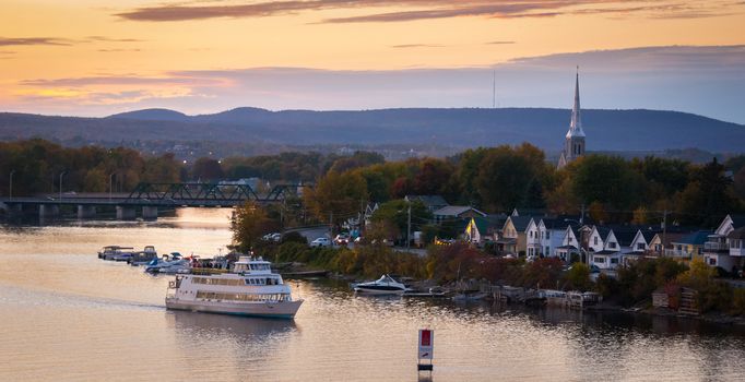 A riverboat of sight-seers cruise the river on a lovely warm summer evening