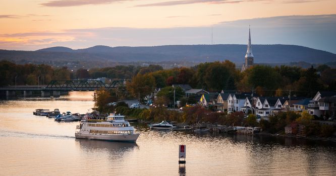 A riverboat of sight-seers cruise the river on a lovely warm summer evening