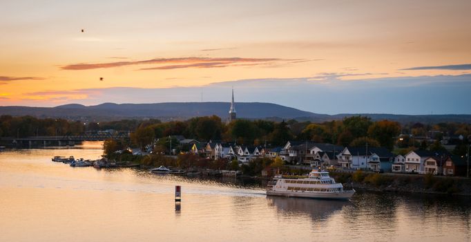 A riverboat of sight-seers cruise the river on a lovely warm summer evening