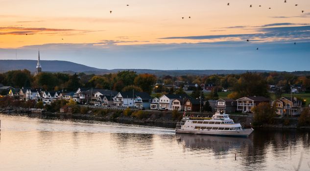 A riverboat of sight-seers cruise the river on a lovely warm summer evening