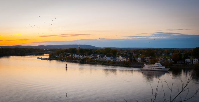 A riverboat of sight-seers cruise the river on a lovely warm summer evening