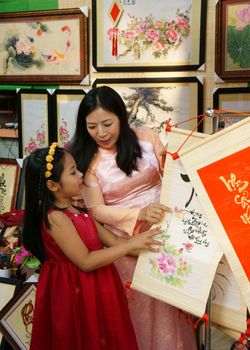 HO CHI MINH CITY, VIET NAM- FEB 7: Atmosphere of springtime with colorful scene on Saigon street, Vietnamese woman, unidentified kid  happy on spring fair of Tet holiday, Vietnam, Feb 7, 2015