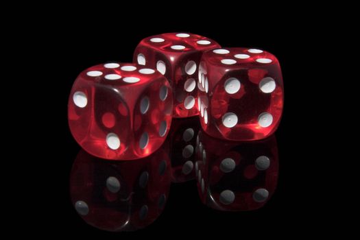 Three red casino dices on the black background