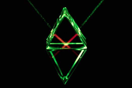 Green laser rays pass through and reflect inside the glass prism