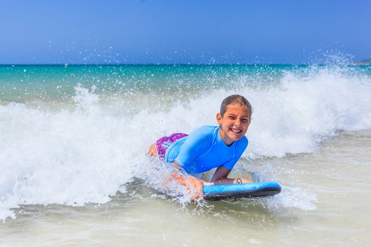 Teenage girl in blue has fun surfing