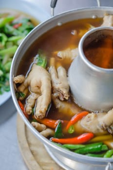 sour and spicy chicken feet soup in hot bowl