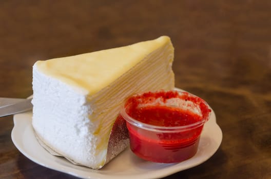 close up crepe cake with strawberry sauce