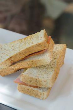 close up toasted sandwich with ham and cheese on dish