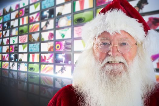Santa smiles in the camera against screen collage showing lifestyle images