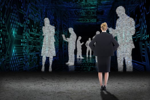 Businesswoman standing with hands on hips against business people in data matrix