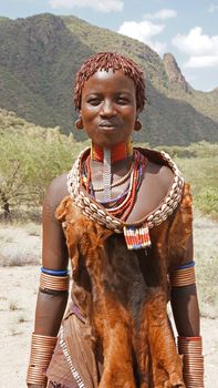 TURMI, ETHIOPIA - NOVEMBER 18, 2014: Young Hamer girl with traditional clothings and hairstyle on November 18, 2014 in Turmi, Ethiopia.