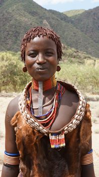 TURMI, ETHIOPIA - NOVEMBER 18, 2014: Young Hamer girl with traditional clothings and hairstyle on November 18, 2014 in Turmi, Ethiopia.