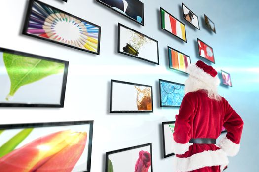 Santa looks away from the camera against screen collage showing lifestyle images