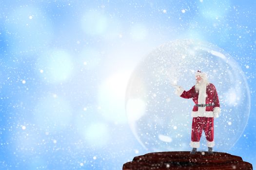 Santa presenting in a snow globe against blue abstract light spot design