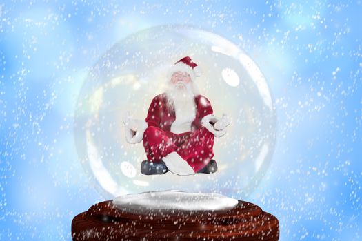 Santa doing yoga in snow globe against blue abstract light spot design