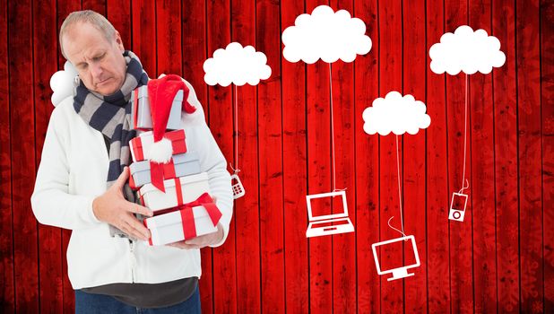 Festive man holding christmas gifts against red wooden planks background