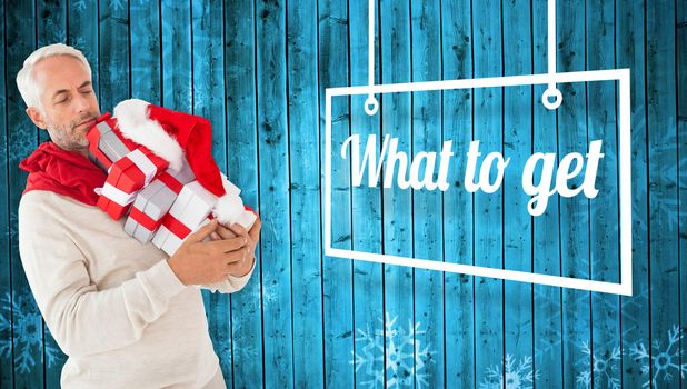 Happy festive man with gifts against snowflake pattern on blue planks
