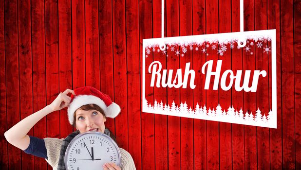 Woman holding a large clock against red wooden planks background