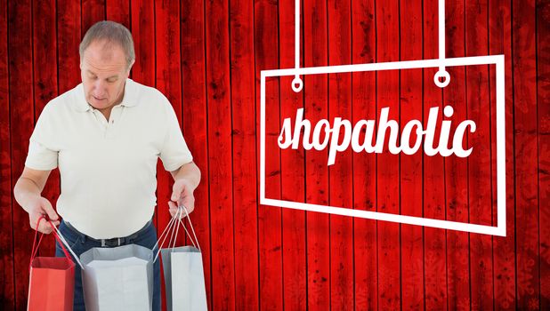 Man looking in shopping bags against red wooden planks background