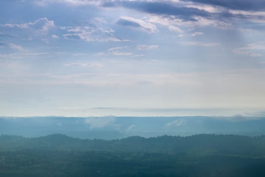 Forested mountains and sky. A slight mist-shrouded mountains and trees. Clear sky