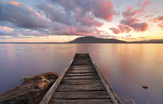 Queens Lake Jetty at Queens Lake Nature Reserve picnic area in Jolly Nose NSW at sunset.