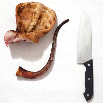 pork ears with knife and blood white background. Concept idea