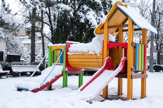 Children playground empty in the snow .