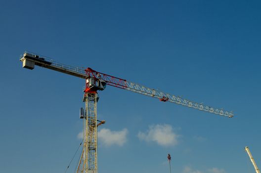 Construction Crane Towering with Construction Details against Blue Sky Outdoors
