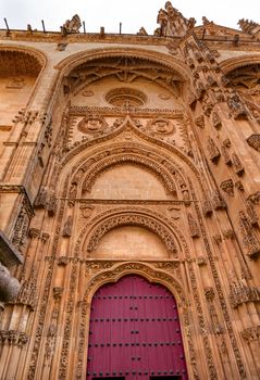 Stone Red Front Door Facade New Salamanca Cathedral Spain.  The New and Old Cathedrals in Salamanca are right next to each other.  New Cathedral was built from 1513 to 1733 and commissioned by Ferdinand V of Castile, Spain. 