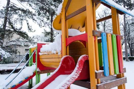 Children playground empty in the snow .