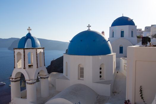 Blue domes and their bell tower in Oia. Santorini