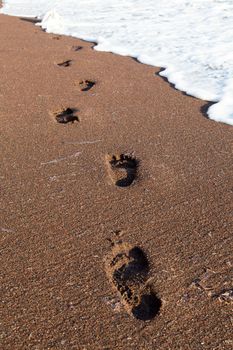 Trail of foot steps on the beach