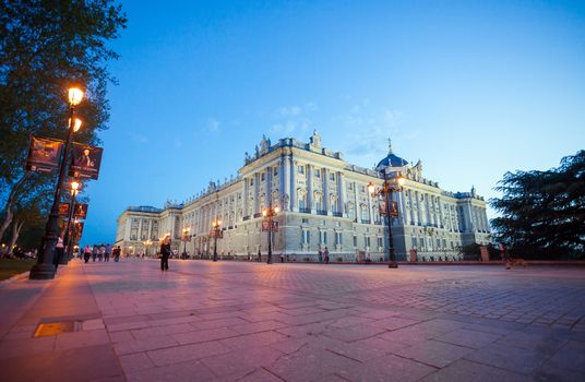 Madrid, Spain - May 10, 2012: Royal palace (Palacio Real de Madrid) with visiting tourists on a spring night in Madrid, Spain