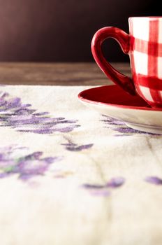 Detail of colorful coffee cup laid on wooden vintage table