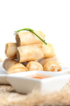 Plate of Thai spring rolls appetizer with garnish. Shallow depth of field.