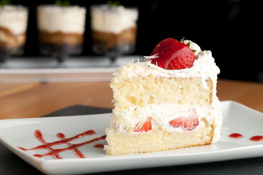 Slice of strawberry shortcake with white chocolate shavings.