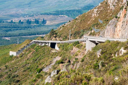 View of Sir Lowreys Pass in the Hottentots-Holland mountains near Somerset West, South Africa. The bridges over the old, unused roalroad is visible. Safety nets keep rockfalls away from the road
