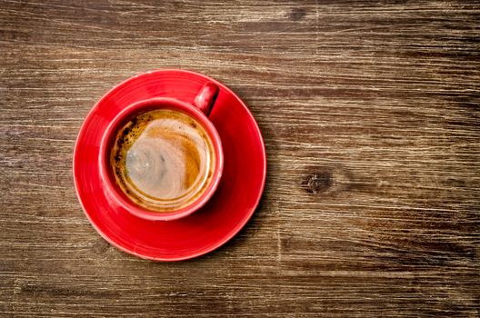 Top view of coffee in red cup on wooden vintage table