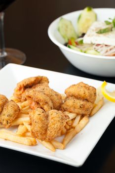 Fried shrimp and french fries plate garnished with lemon.