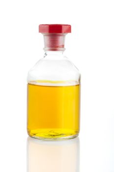 Clear glass bottle with yellow liquid and red stopper.