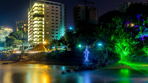 The still waters of the Atlantic ocean reflecting the colourful lights along the shores of downtown Dakar