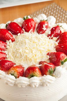 Top view of an entire strawberry shortcake with white chocolate shavings.