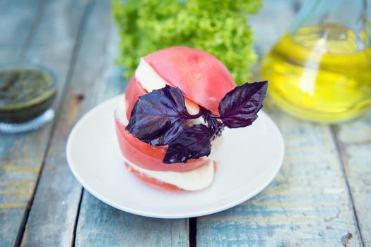 salad with mozzarella,tomatoes,dark basil on wooden retro background