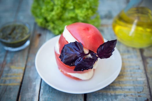 salad with mozzarella,tomatoes,dark basil on wooden retro background