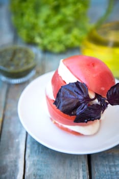 salad with mozzarella,tomatoes,dark basil on wooden retro background