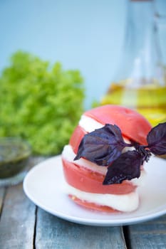 salad with mozzarella,tomatoes,dark basil on wooden retro background