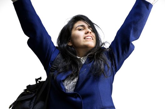 Happy latina teen girl wearing a backpack with arms raised in the air