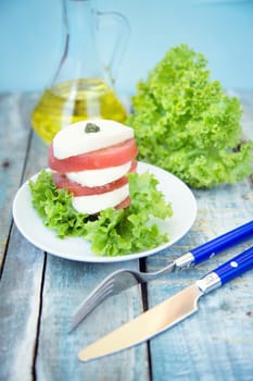 salad with mozzarella,tomatoes,dark basil on wooden retro background